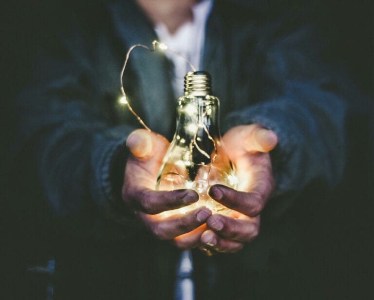 Illustration énergétique avec une ampoule lumineuse tenue par des mains, symbolisant le magnétisme et la transmission d'énergie. Ne se substitue pas à la médecin conventionnelle.